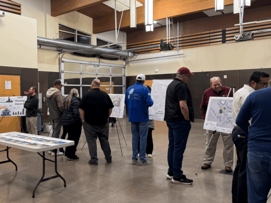 Yelm community members gather in front of posters detailing the city's comprehensive plan.